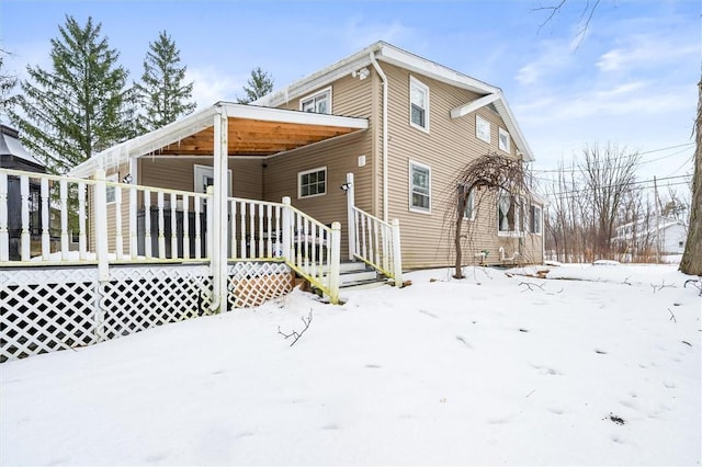 view of snow covered rear of property