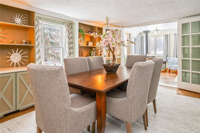 dining area with a wealth of natural light, light hardwood / wood-style floors, and a textured ceiling