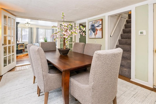 dining area with a textured ceiling and light hardwood / wood-style floors