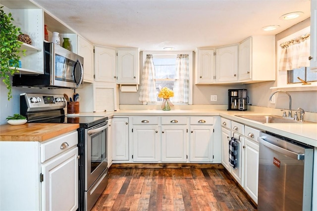 kitchen featuring appliances with stainless steel finishes, butcher block counters, sink, white cabinets, and dark hardwood / wood-style flooring