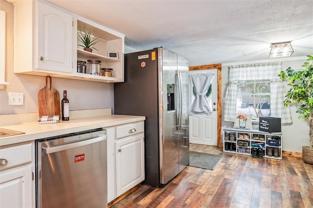 kitchen with white cabinetry, stainless steel appliances, dark wood-type flooring, and a textured ceiling