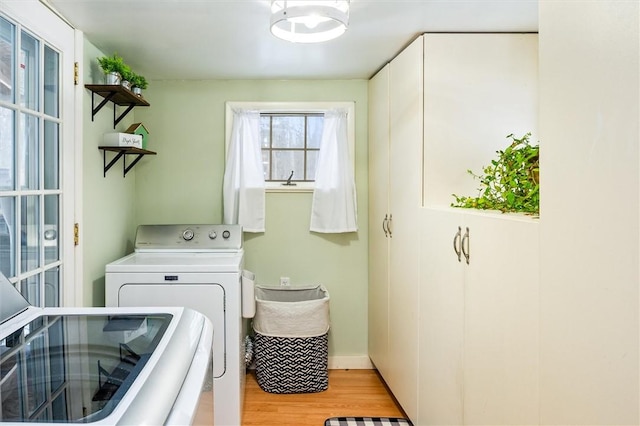 laundry area with washer and dryer and light wood-type flooring