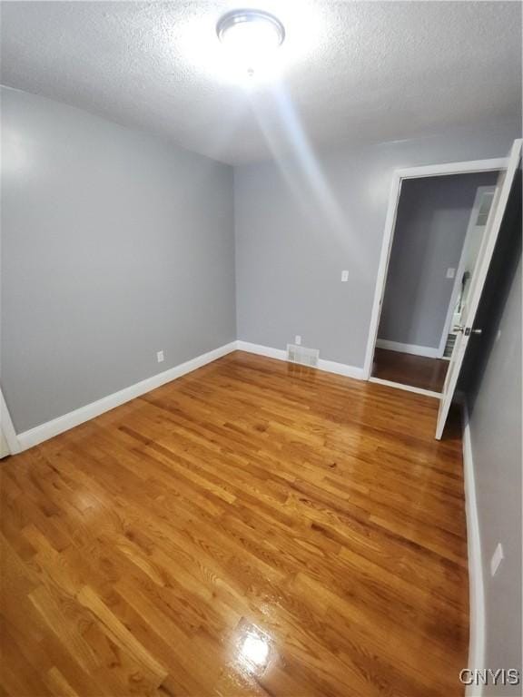 bonus room with hardwood / wood-style flooring and a textured ceiling