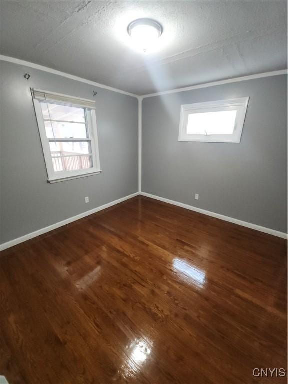 unfurnished room featuring ornamental molding, dark hardwood / wood-style flooring, and a textured ceiling