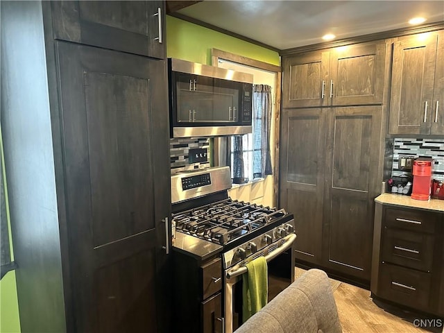 kitchen with dark brown cabinetry, appliances with stainless steel finishes, and backsplash