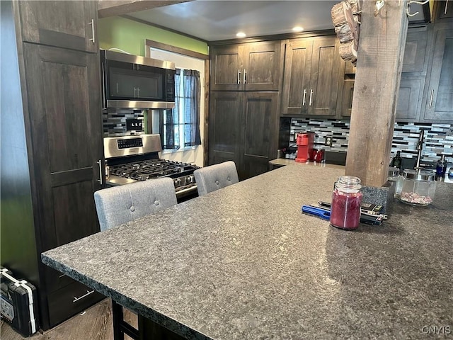 kitchen featuring tasteful backsplash, dark brown cabinets, and appliances with stainless steel finishes