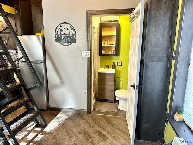 bathroom with vanity, toilet, and hardwood / wood-style floors