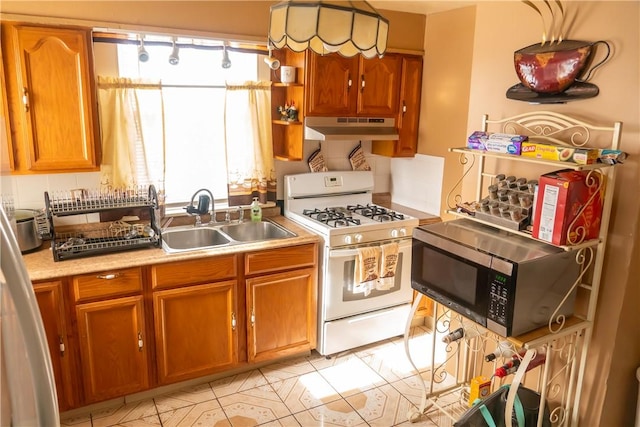 kitchen with a healthy amount of sunlight, white gas range, and sink