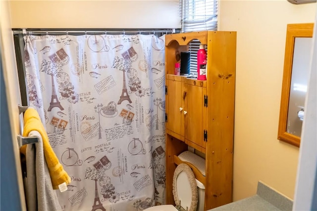 bathroom featuring curtained shower and toilet