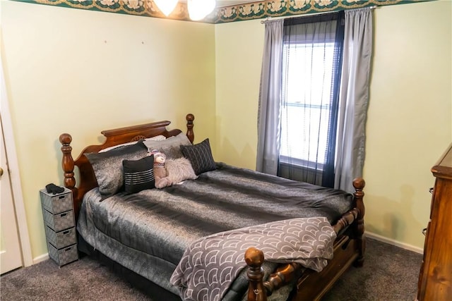 bedroom featuring multiple windows and dark carpet