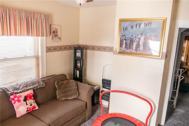 living room with ceiling fan and dark carpet