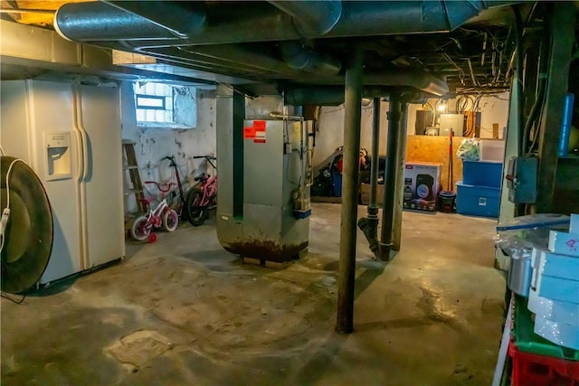 basement featuring white fridge with ice dispenser and heating unit