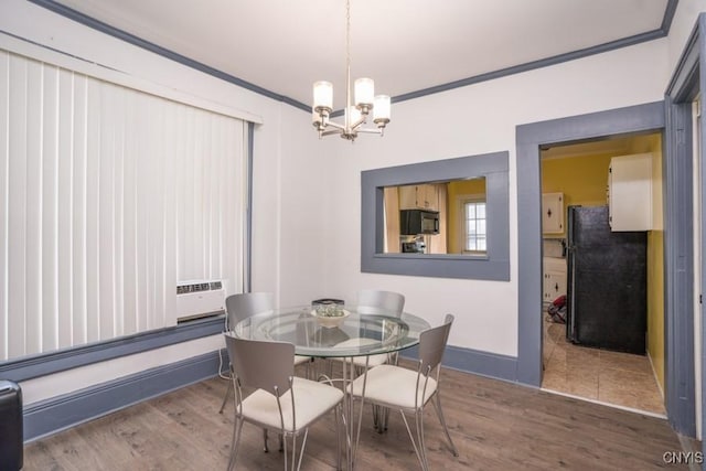 dining area featuring hardwood / wood-style flooring, crown molding, and an inviting chandelier