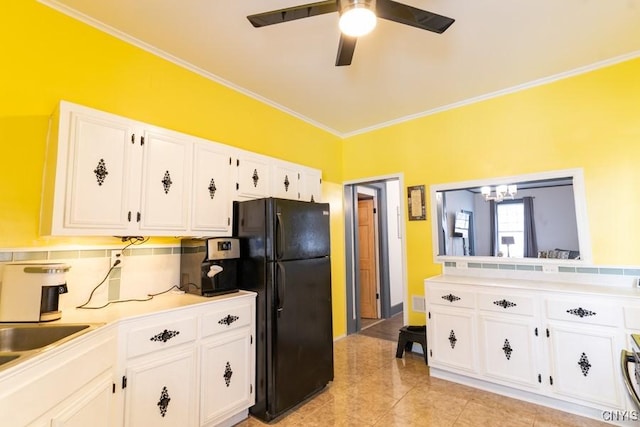 kitchen with black refrigerator, white cabinetry, backsplash, ceiling fan, and crown molding