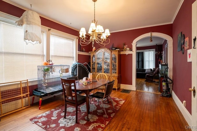 dining space featuring an inviting chandelier, hardwood / wood-style flooring, and ornamental molding