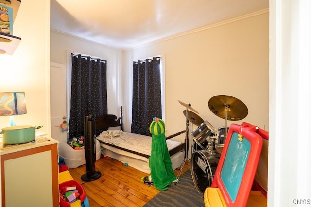 bedroom featuring crown molding and wood-type flooring