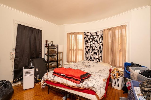 bedroom with hardwood / wood-style flooring and ornamental molding