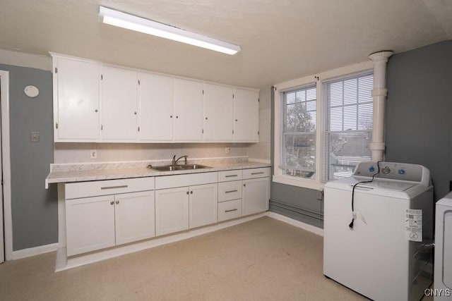 washroom featuring sink, cabinets, and independent washer and dryer