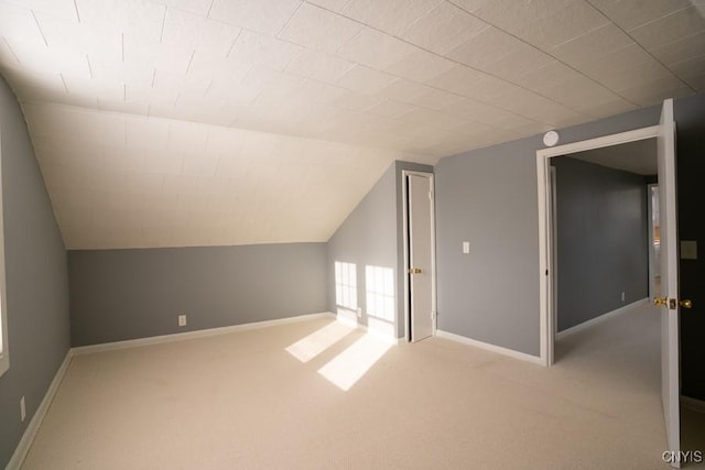 additional living space featuring light carpet and lofted ceiling