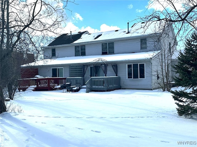 snow covered rear of property featuring a deck