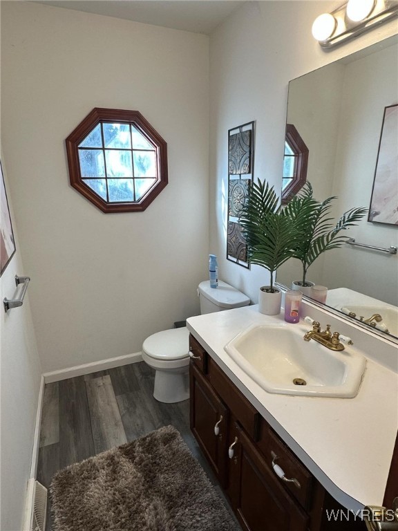 bathroom featuring hardwood / wood-style flooring, vanity, and toilet