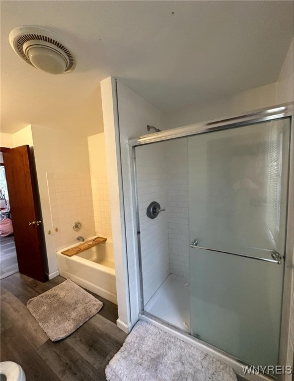 bathroom with wood-type flooring and independent shower and bath