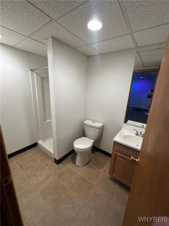 bathroom featuring walk in shower, a paneled ceiling, vanity, and toilet