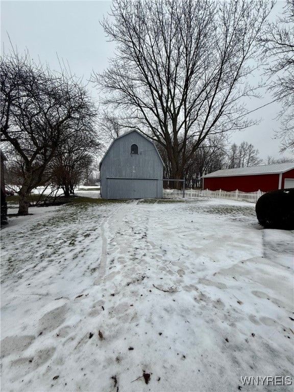 snowy yard featuring an outbuilding