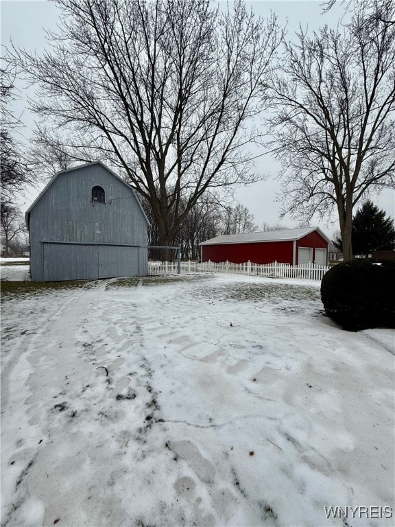 snowy yard with an outbuilding