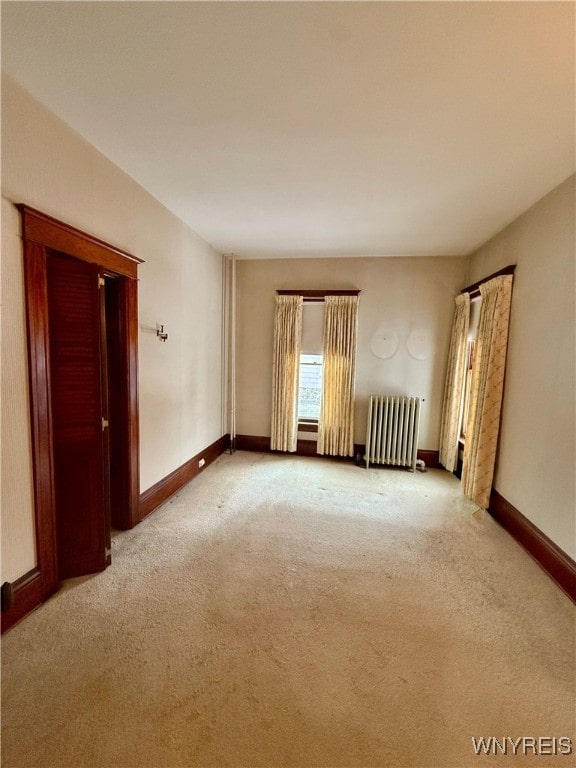 carpeted empty room with radiator