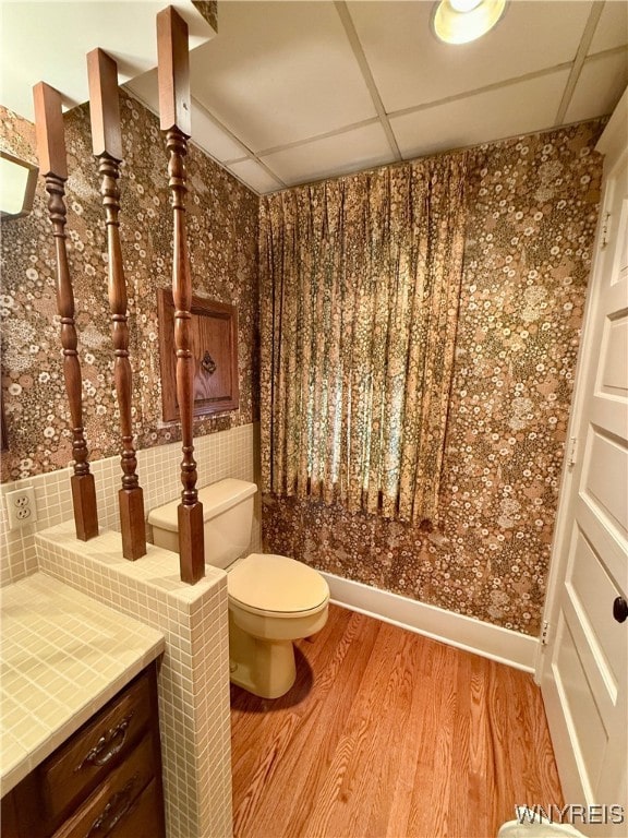 bathroom featuring hardwood / wood-style flooring, a paneled ceiling, and toilet