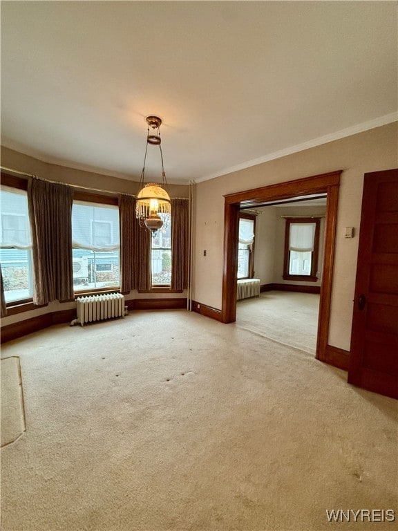 unfurnished room featuring crown molding, radiator, and carpet floors