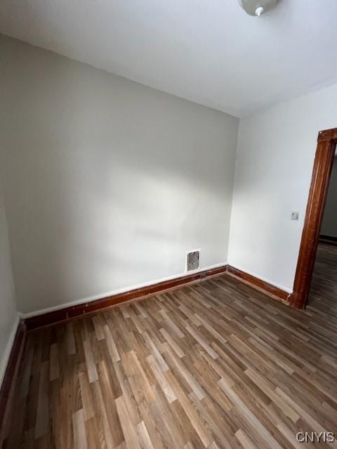 1218 City St, Utica, NY 13502 - spare room featuring wood finished floors, visible vents, and baseboards