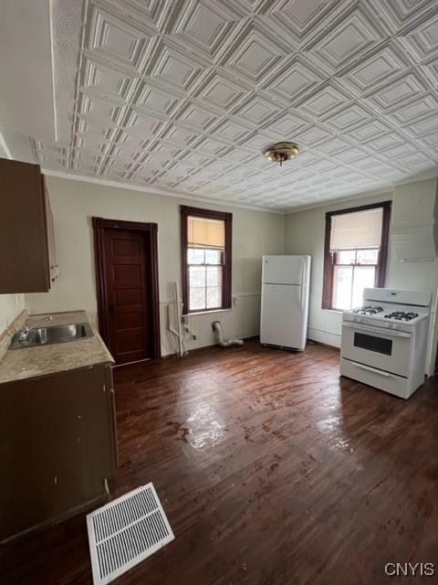 kitchen with dark hardwood / wood-style floors, crown molding, sink, and white appliances