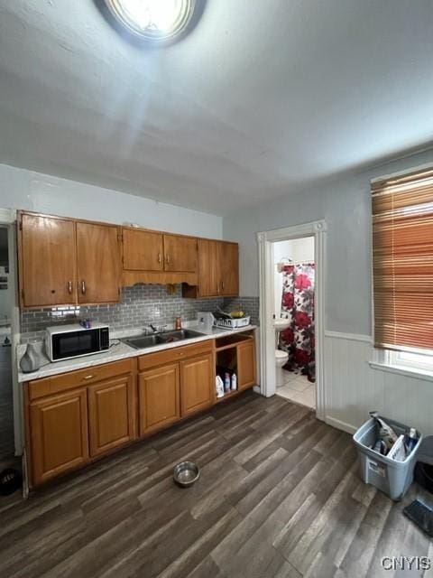 kitchen with sink, dark wood-type flooring, and backsplash