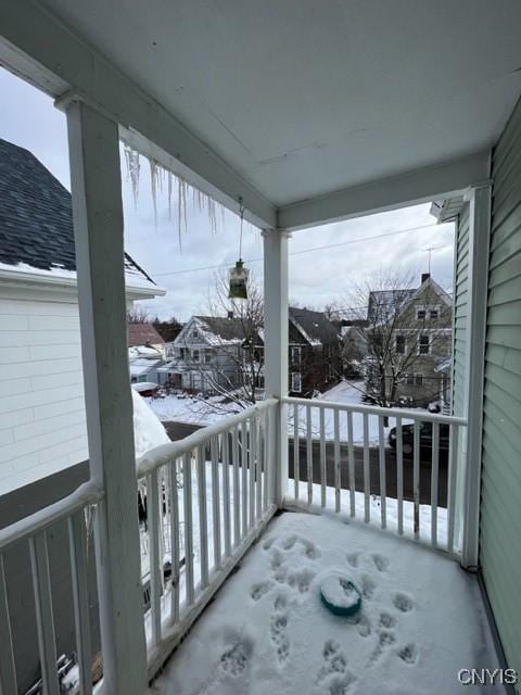 view of snow covered back of property