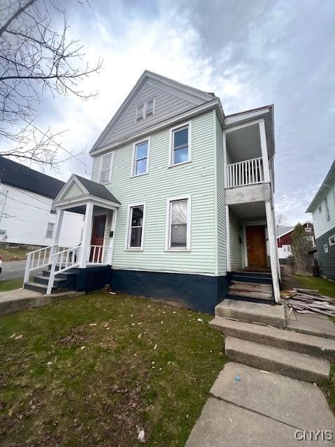 1218 City St, Utica, NY 13502 - view of front of home with a front yard and a balcony