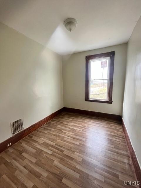 1218 City St, Utica, NY 13502 - spare room with visible vents, baseboards, and wood finished floors