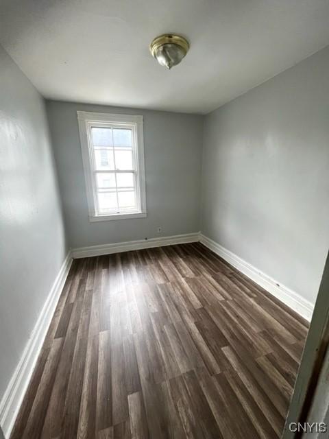 1218 City St, Utica, NY 13502 - unfurnished room with baseboards and dark wood-style flooring