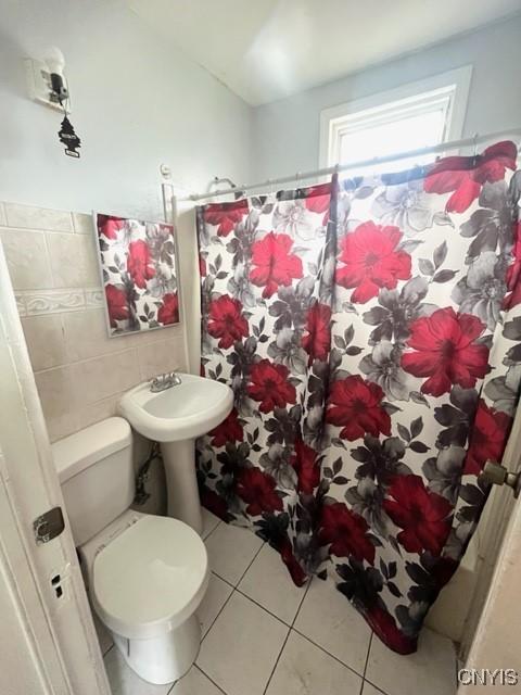 1218 City St, Utica, NY 13502 - full bathroom featuring tile patterned floors, toilet, tile walls, and a shower with shower curtain