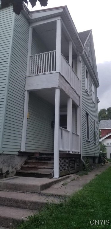 1218 City St, Utica, NY 13502 - view of side of property with entry steps and a balcony