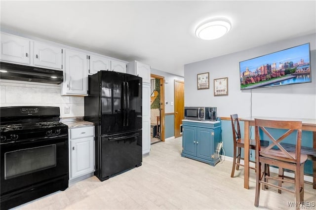 kitchen featuring blue cabinetry, tasteful backsplash, black appliances, light hardwood / wood-style floors, and white cabinets