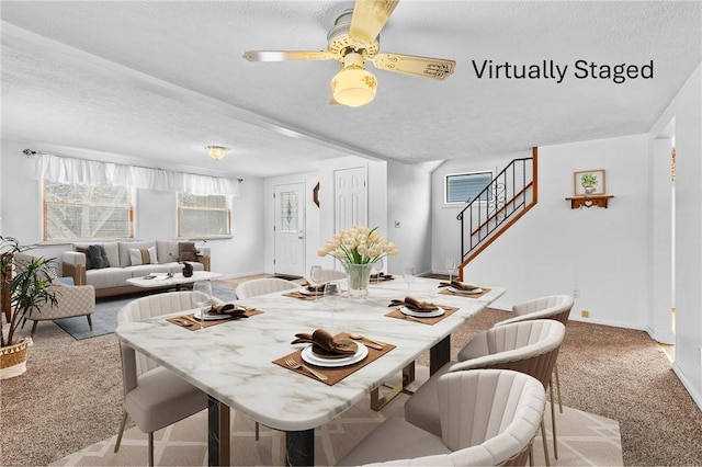 carpeted dining area featuring ceiling fan and a textured ceiling