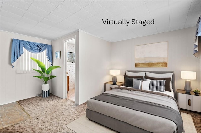 carpeted bedroom featuring crown molding and connected bathroom