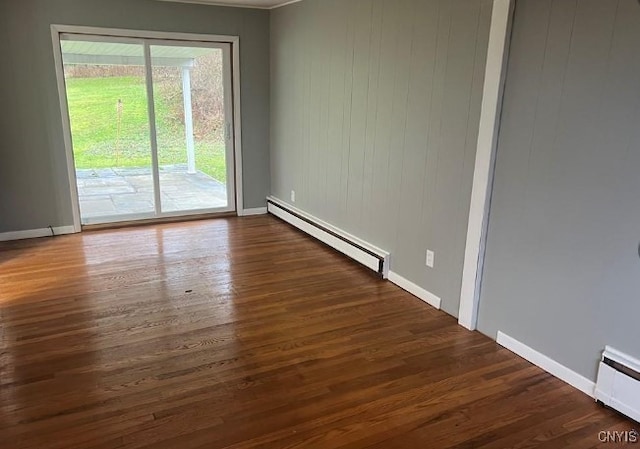 spare room featuring dark wood-type flooring and baseboard heating