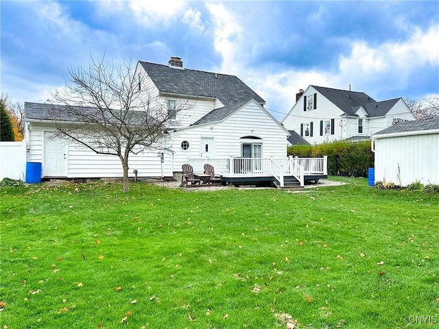 rear view of property featuring a wooden deck and a lawn