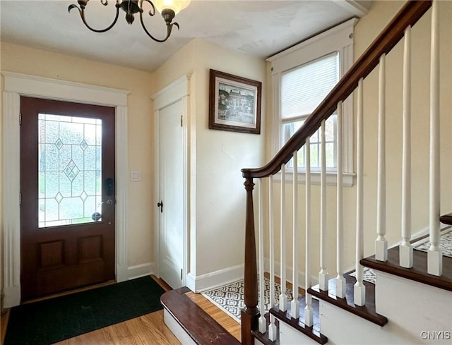 foyer entrance featuring wood-type flooring and a notable chandelier