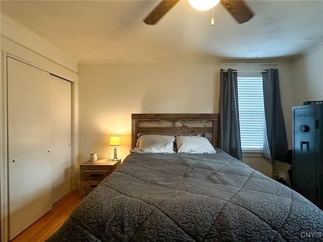 bedroom featuring wood-type flooring, ornamental molding, a closet, and ceiling fan