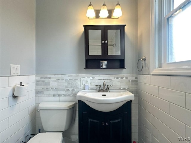 bathroom with vanity, tile walls, and toilet