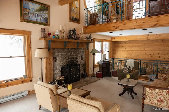 living room with baseboard heating, a fireplace, carpet floors, and wood walls